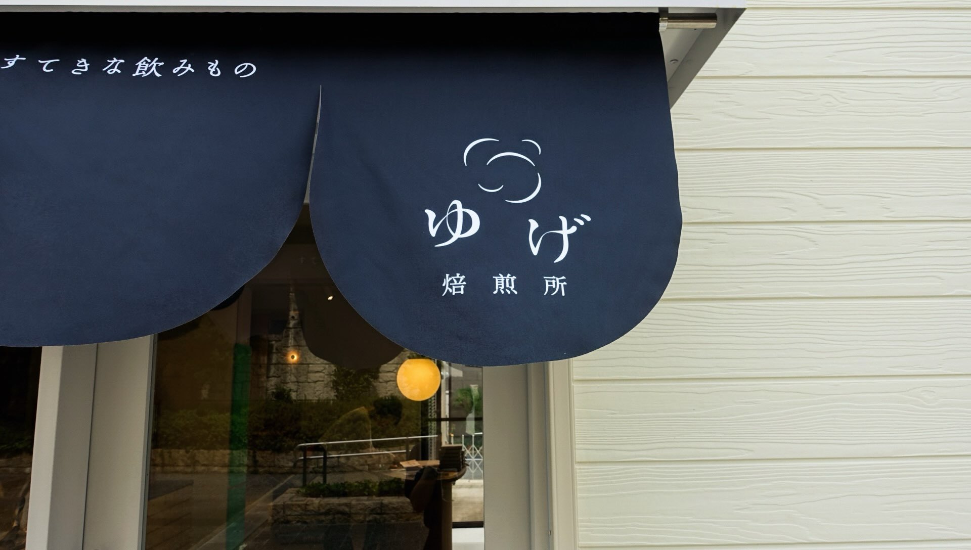 甲南山手店の入口にかかる、ゆげ焙煎所のロゴ入りの日よけ